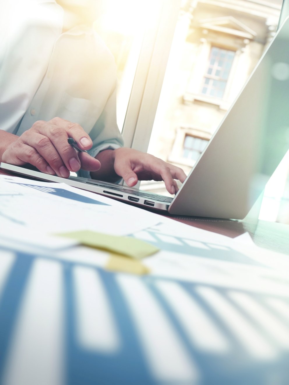 business documents on office table with smart phone and digital tablet and graph business diagram and man working in the background